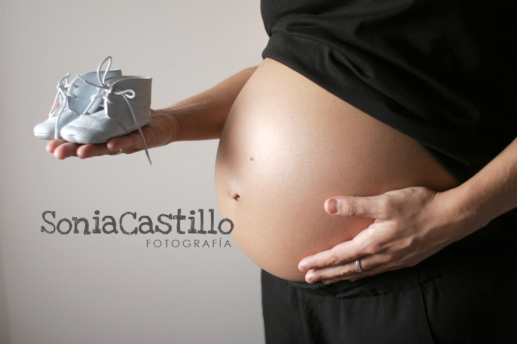 fotografía embarazada con zapatos de bebe en la mano
